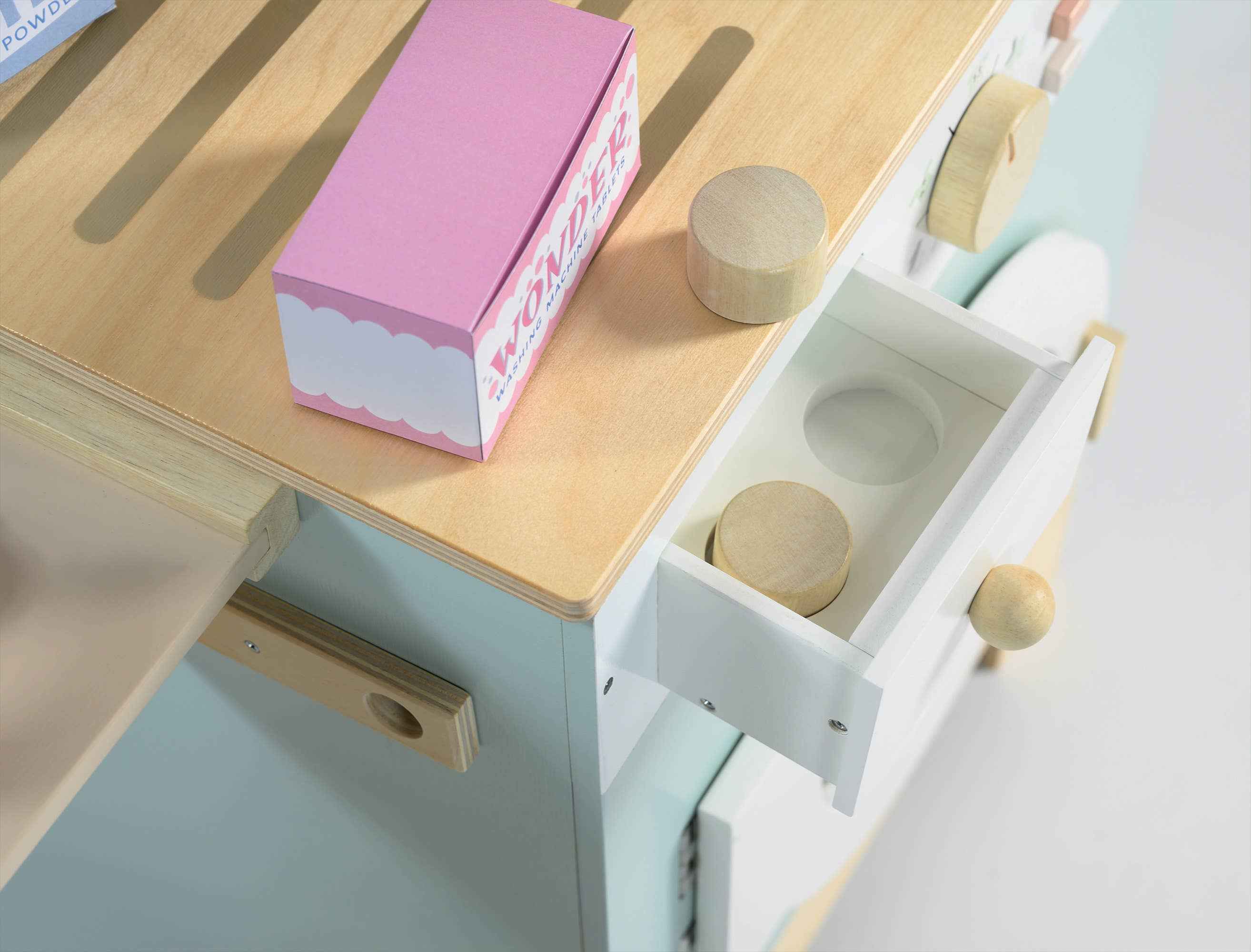 Detail of Tender Leaf Wooden Laundrette showing open drawer with wooden knobs and pretend detergent box on top.