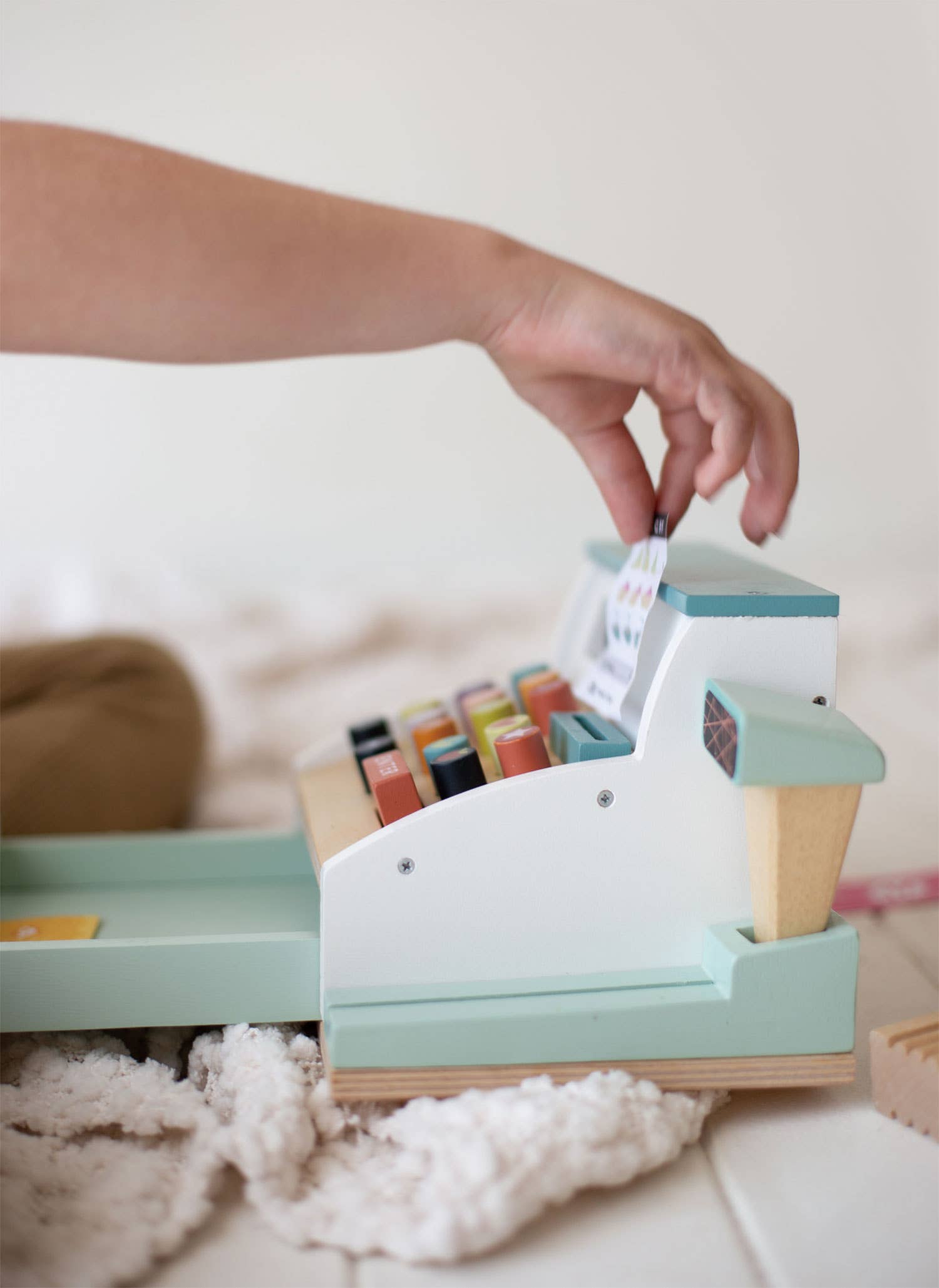 Side view of child inserting receipt into Wooden Role Play Shop Till & Scanner - General Stores Till, simulating real store experience.