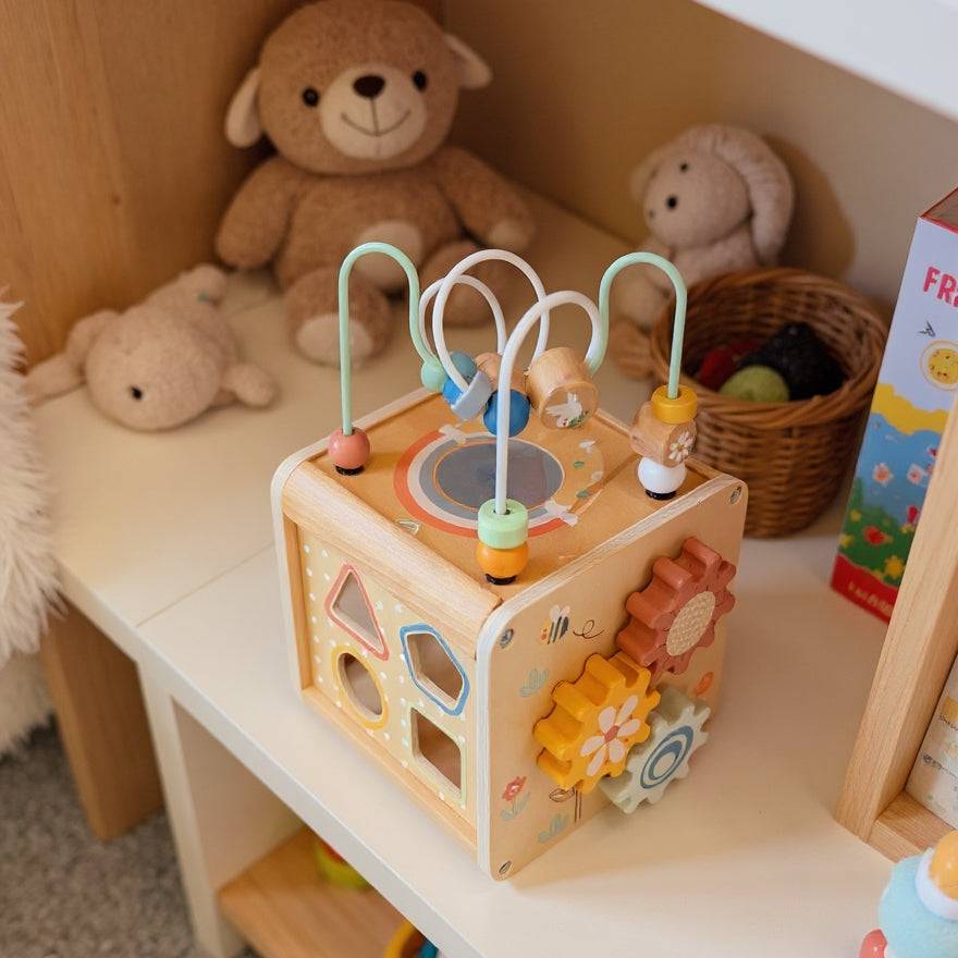 ThinkNest Activity Cube placed on nursery shelf, showcasing interactive gears and bead maze for early childhood development.