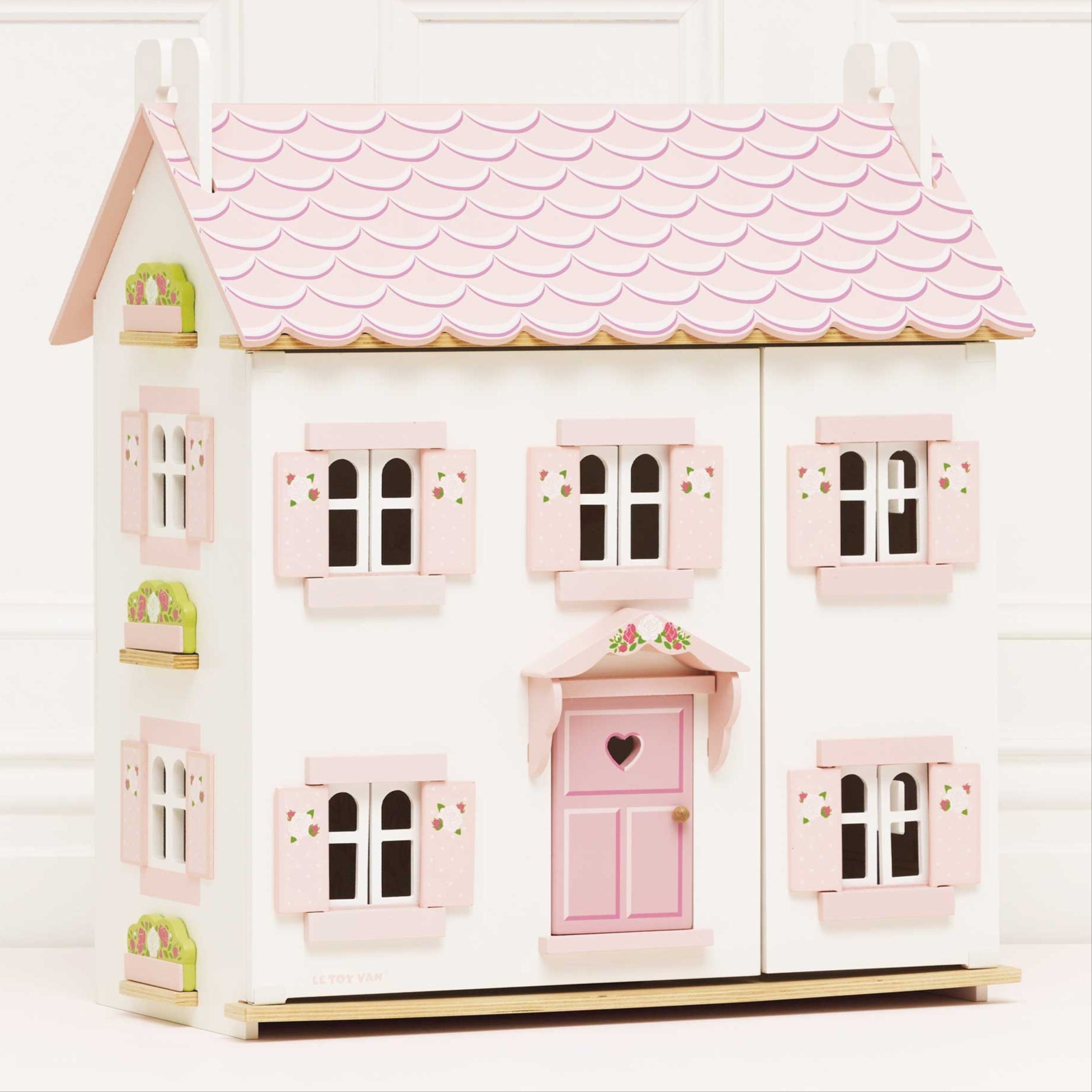 Le Toy Van Sophie's Wooden Dolls House with pink roof, floral shutters, and heart-shaped door, made from FSC-certified wood.
