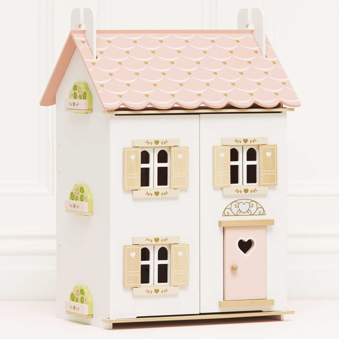 Le Toy Van Roseheart Wooden Dolls House with pink scalloped roof, heart-shaped door, and shuttered windows, ideal for imaginative play.