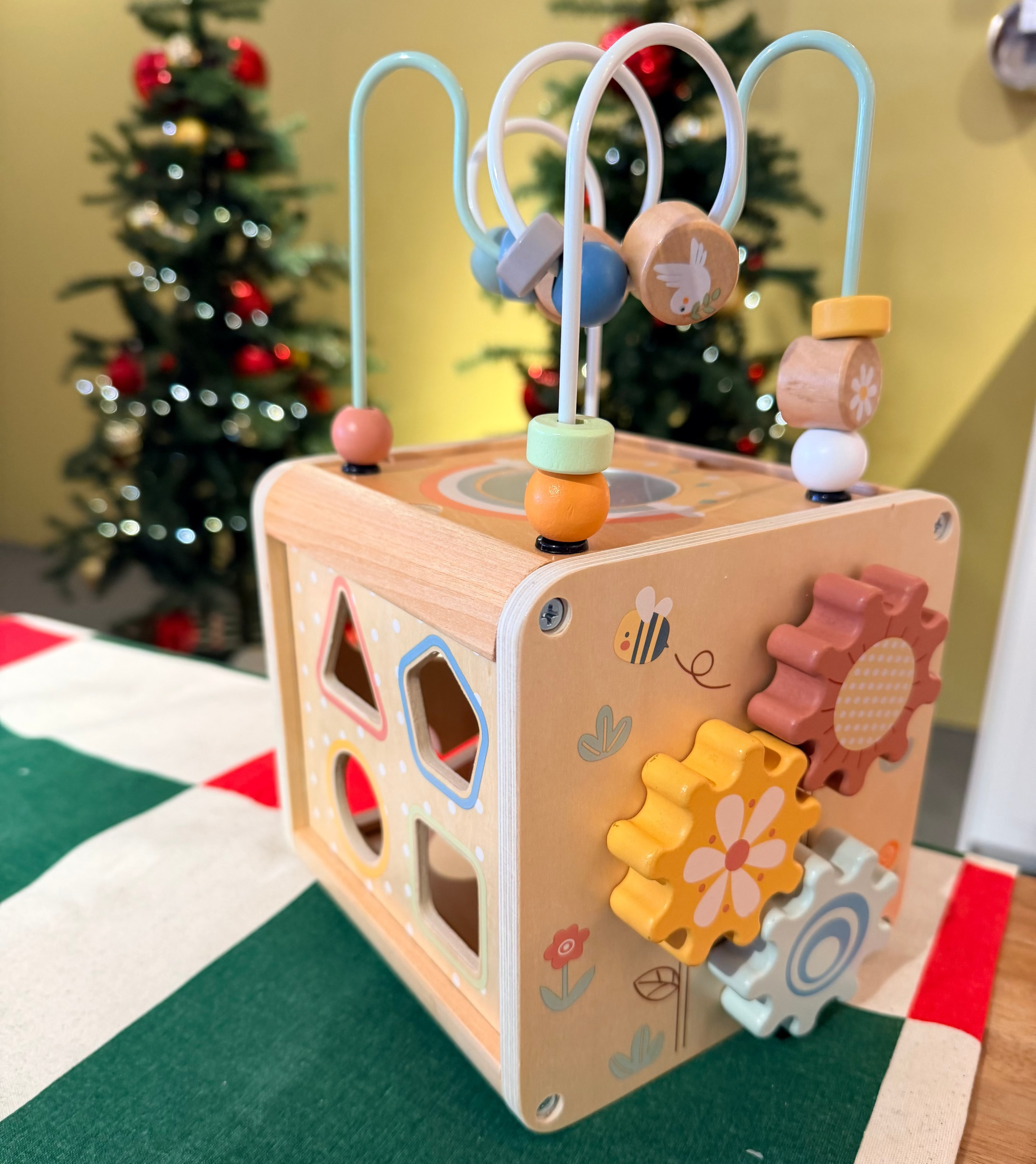 ThinkNest Wooden Activity Cube displayed in festive setting with bead maze and gears, perfect holiday gift for toddlers 12+ months.