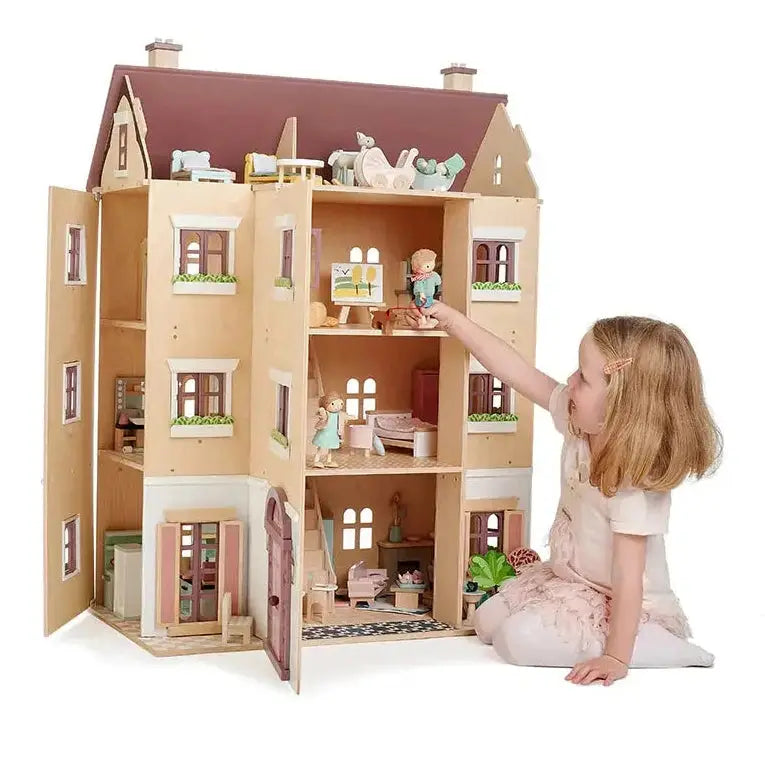 Young girl engaging with Fantail Hall wooden dolls house, arranging furniture and dolls inside its spacious, beautifully designed interior.
