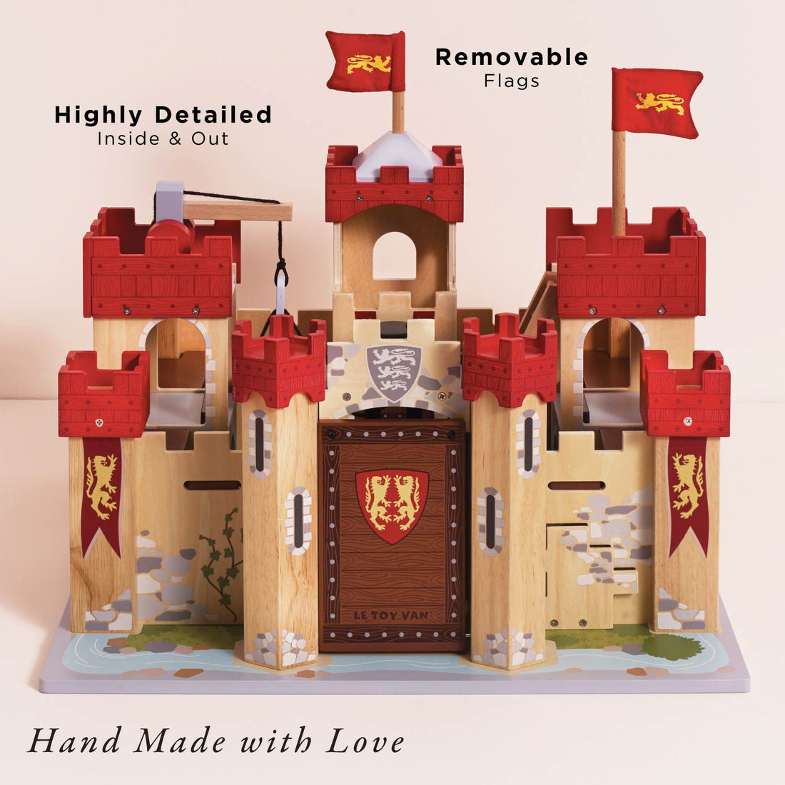 Le Toy Van Lionheart Wooden Play Castle with red turrets, drawbridge, and medieval design, ideal for imaginative pretend play for kids age 3+.