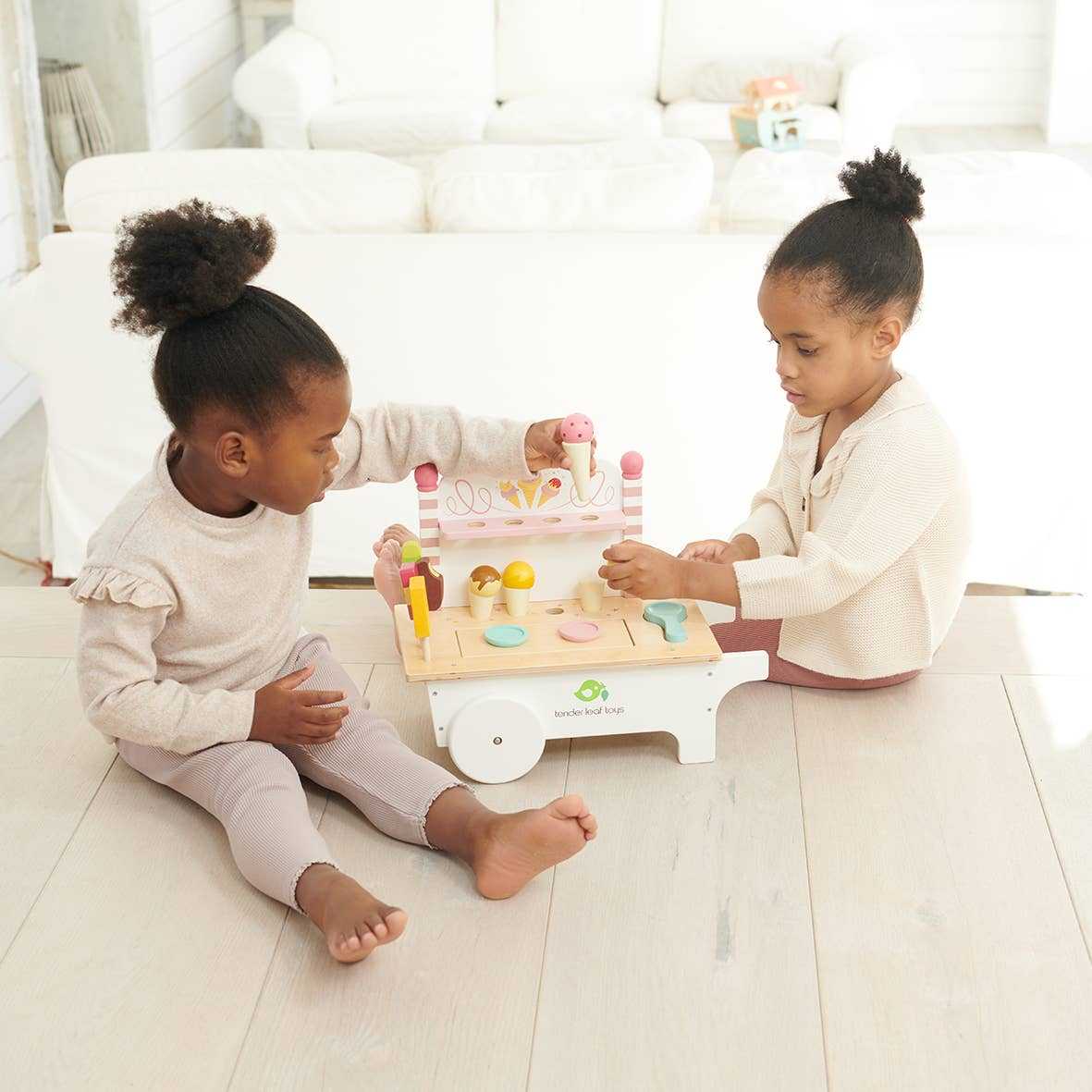Two children playing with the Mini Ice Cream Cart Wooden Role Play Toy, engaging in imaginative food play with wooden cones and scoops.
