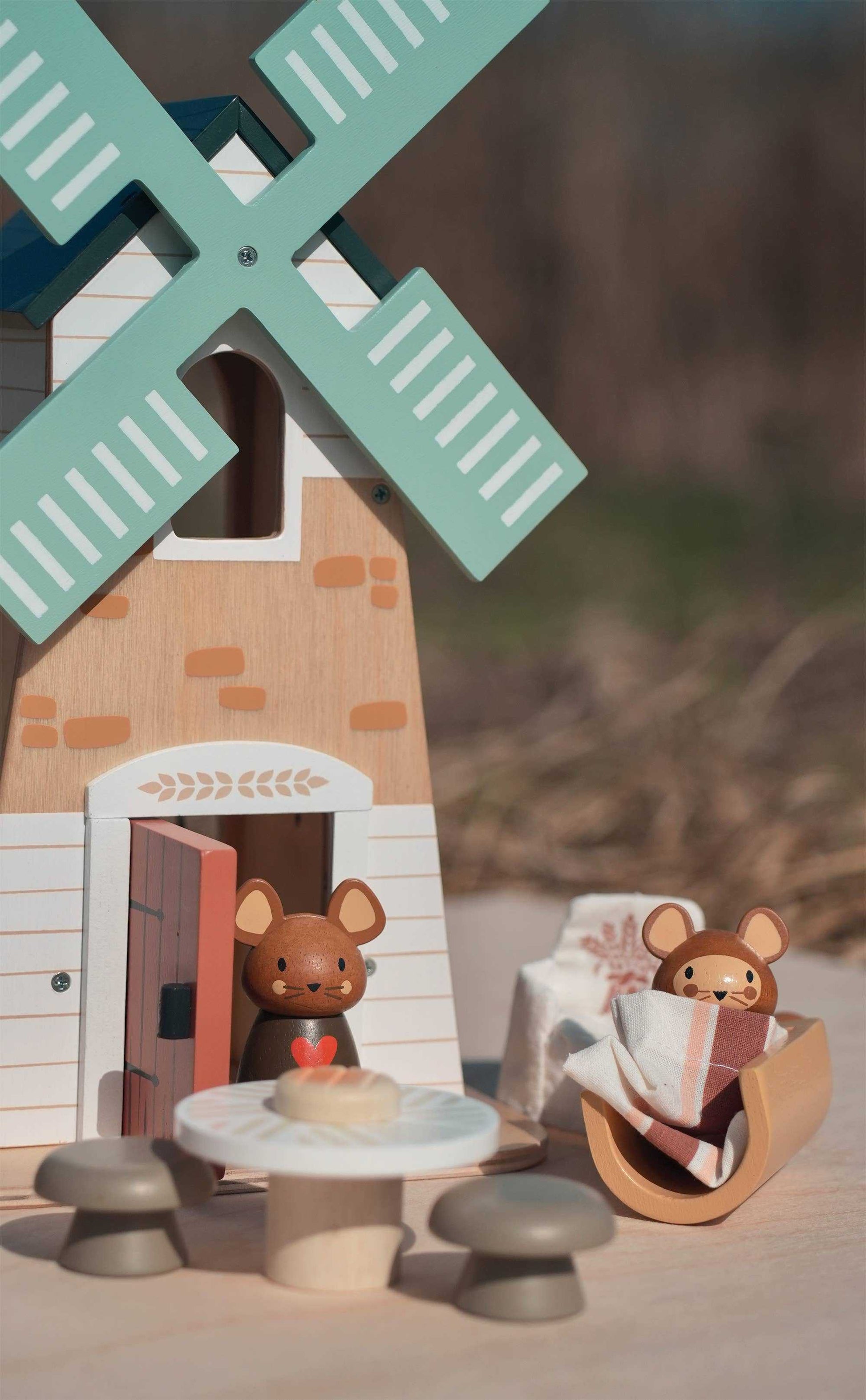 Close-up of Penny Windmill Character Play Set Wooden Toy showing two mouse figurines near a table and windmill door in a cozy outdoor setting.