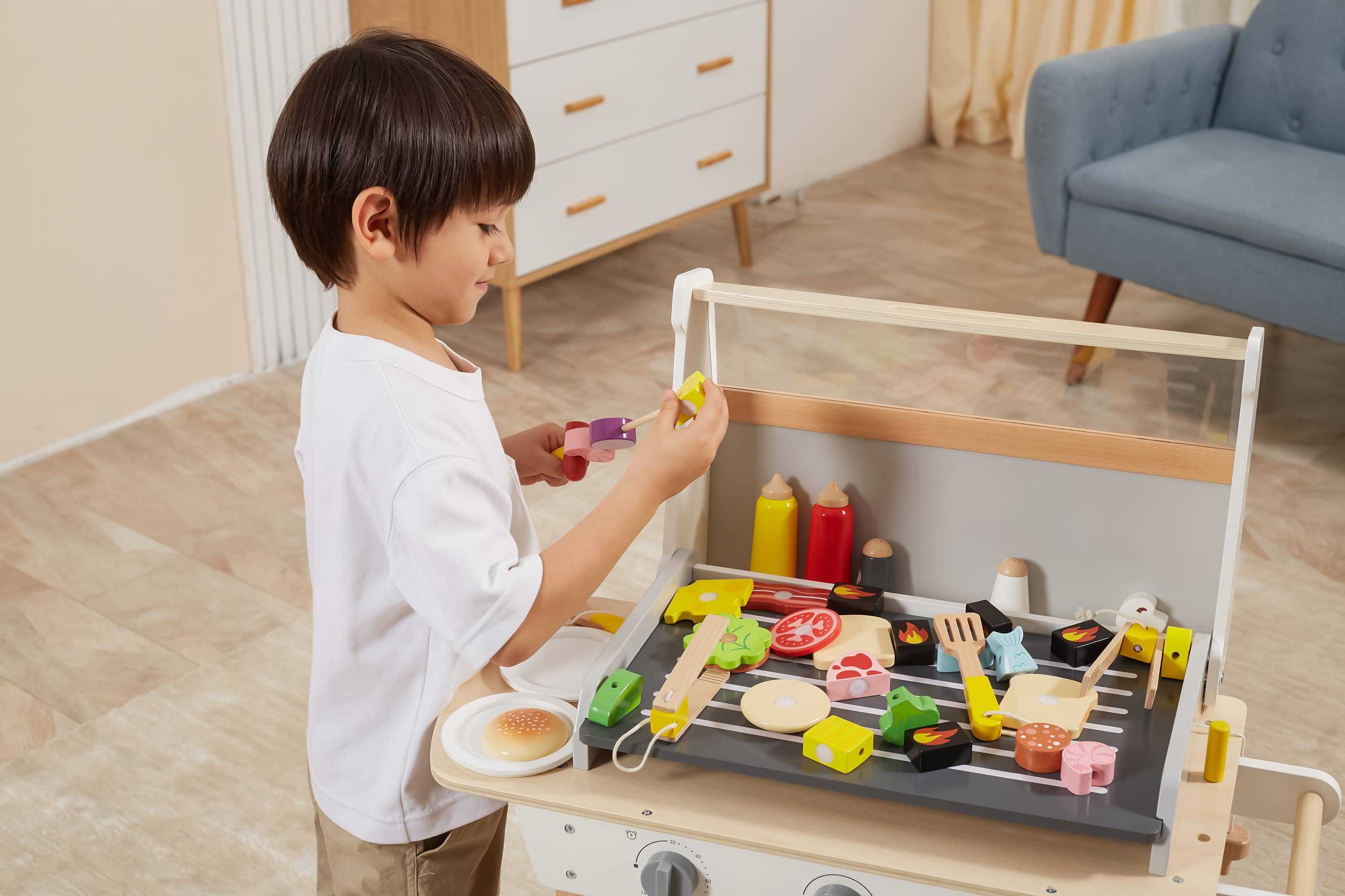 Child assembling wooden skewers on a BBQ play set, featuring colorful food pieces and realistic grilling accessories for creative play.
