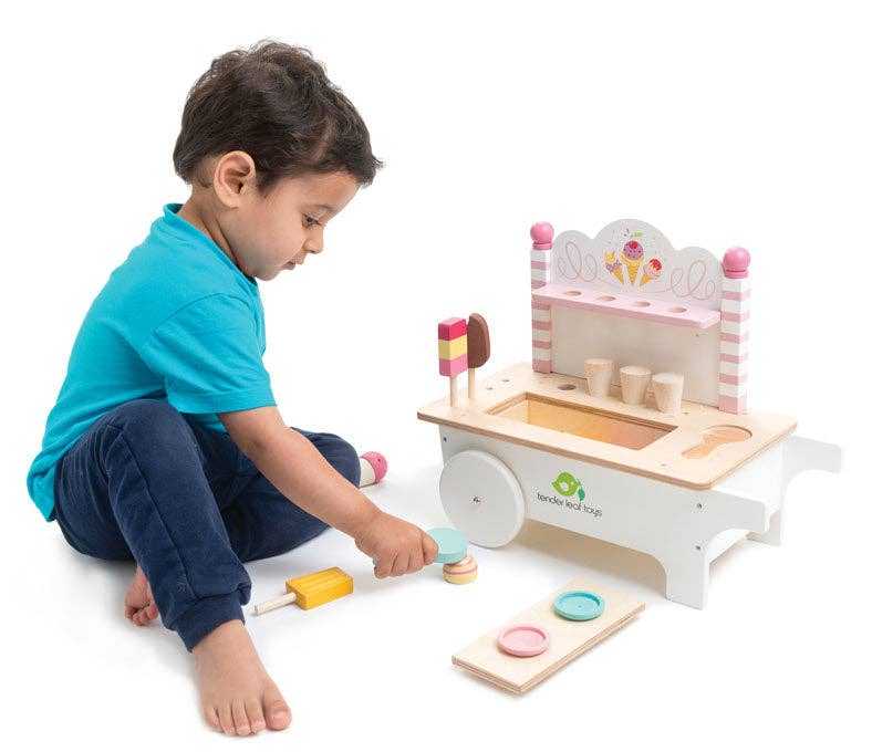 Young boy playing with Mini Ice Cream Cart Wooden Role Play Toy, stacking scoops and popsicles for creative pretend cafe fun.