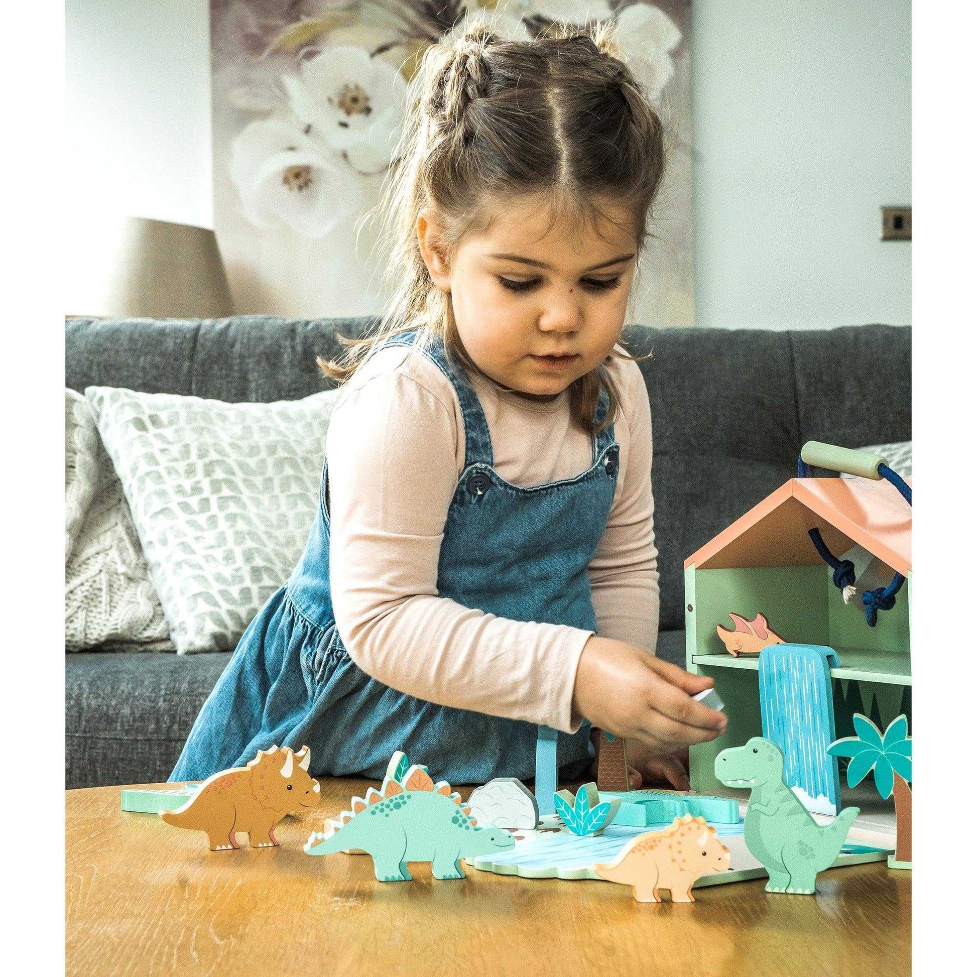 Young girl interacting with the Wooden Dinosaur Toy Play Set - 21 Pieces inc Trex by Orange Tree Toys, ideal for imaginative play.