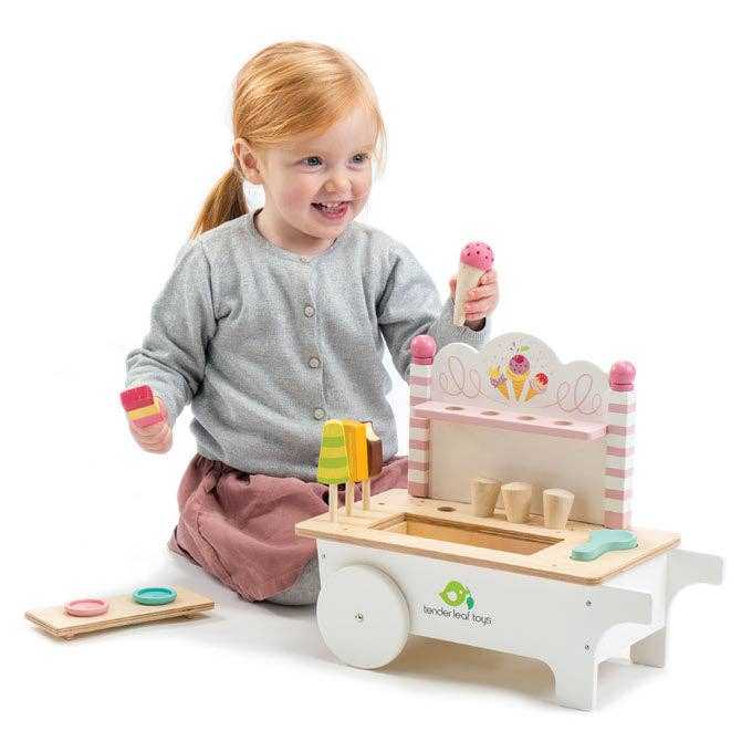 Smiling girl enjoying the Mini Ice Cream Cart Wooden Role Play Toy, holding colorful wooden ice cream pieces for role play fun.