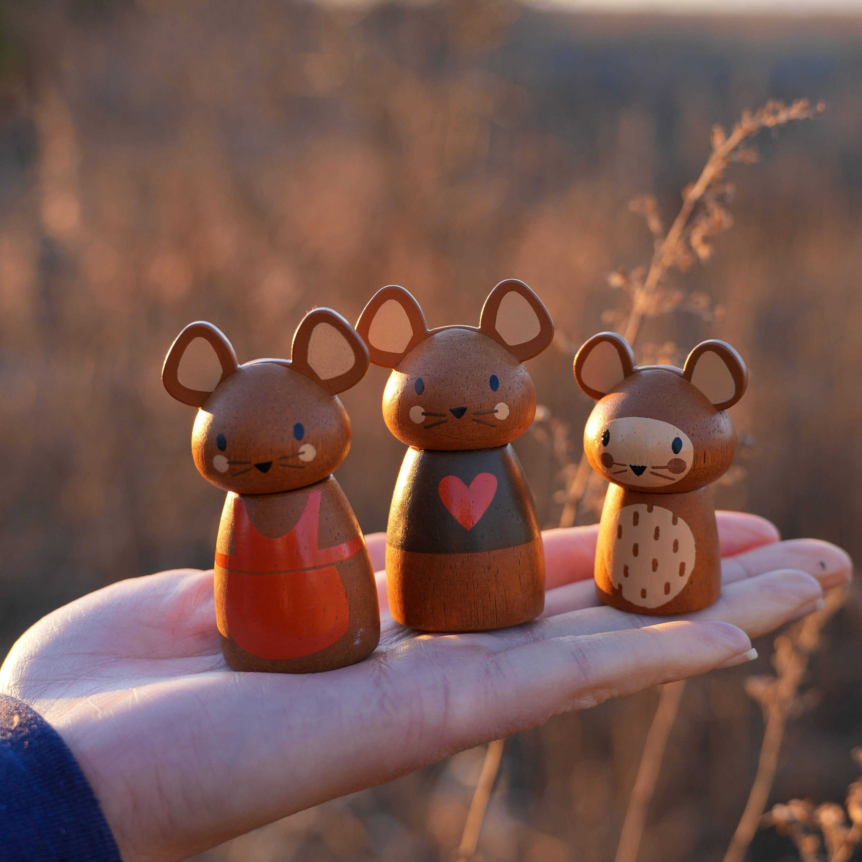 Three wooden mouse figurines from the Penny Windmill Character Play Set Wooden Toy displayed on a hand, showing detailed painted features.