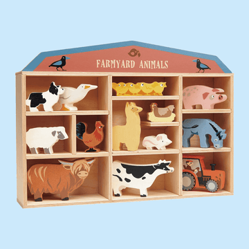 Wooden shelf display labeledFarmyard Animals" featuring colorful wooden animal figures including a cow, pig, sheep, horse, duck, chicks, goat, and a tractor.